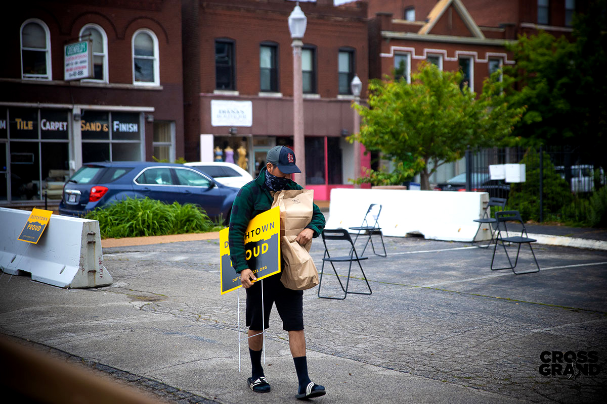 A man witha. Dutchtown Proud sign at the Neighborhood Innovation Center in Downtown Dutchtown, St. Louis, MO.