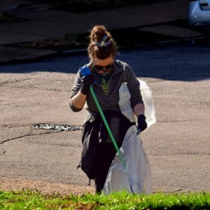 A volunteer picks up trash at Marquette Park in Dutchtown, St. Louis, MO.