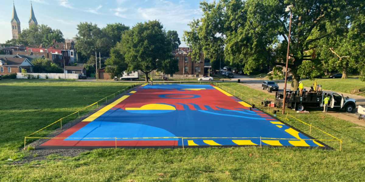 Putting the finishing touches on the futsal court mural at Marquette Park.